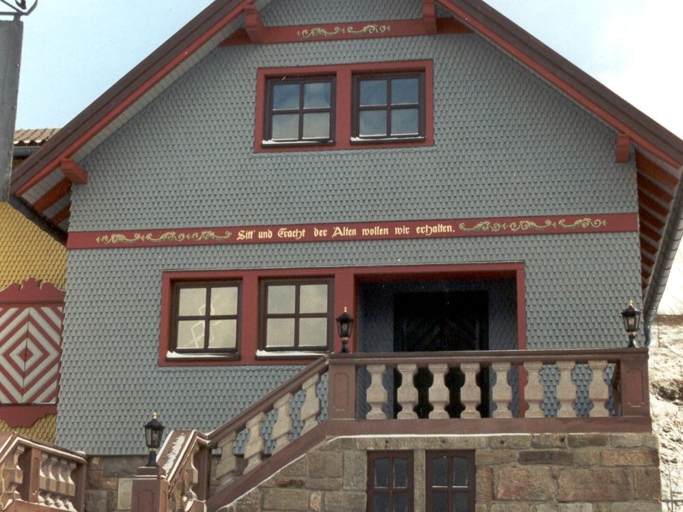 Wohnhaus mit Holzschindeln in grau-rot