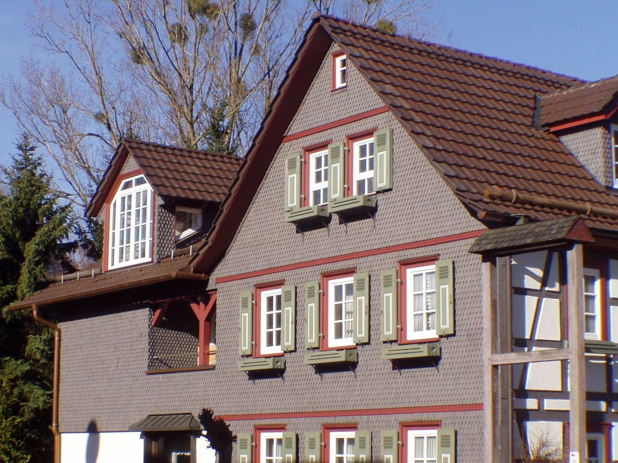 Wohnhaus mit Holzschindeln in grau-rot
